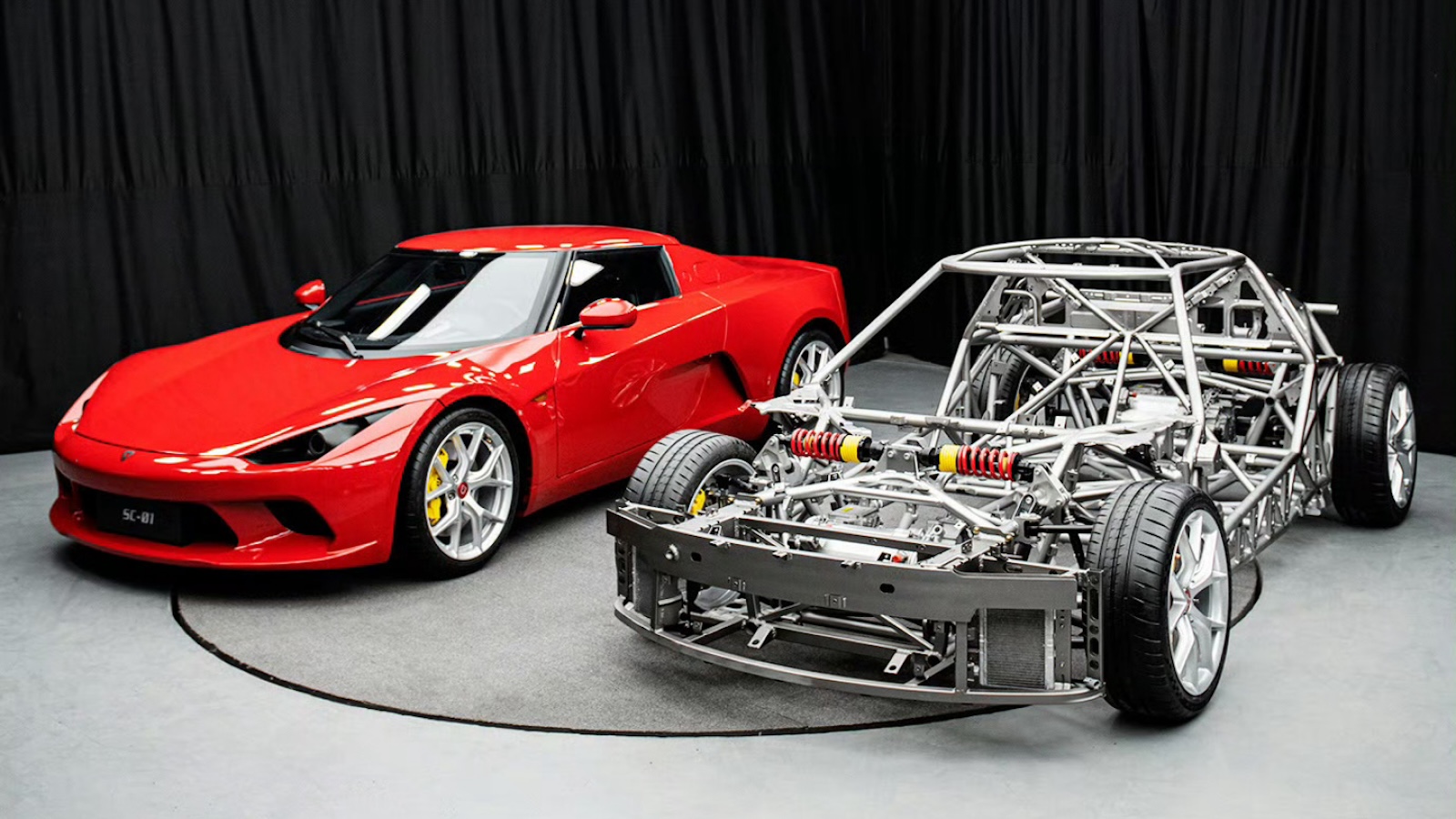 El SC01 rojo junto a su chasis spaceframe desnudo